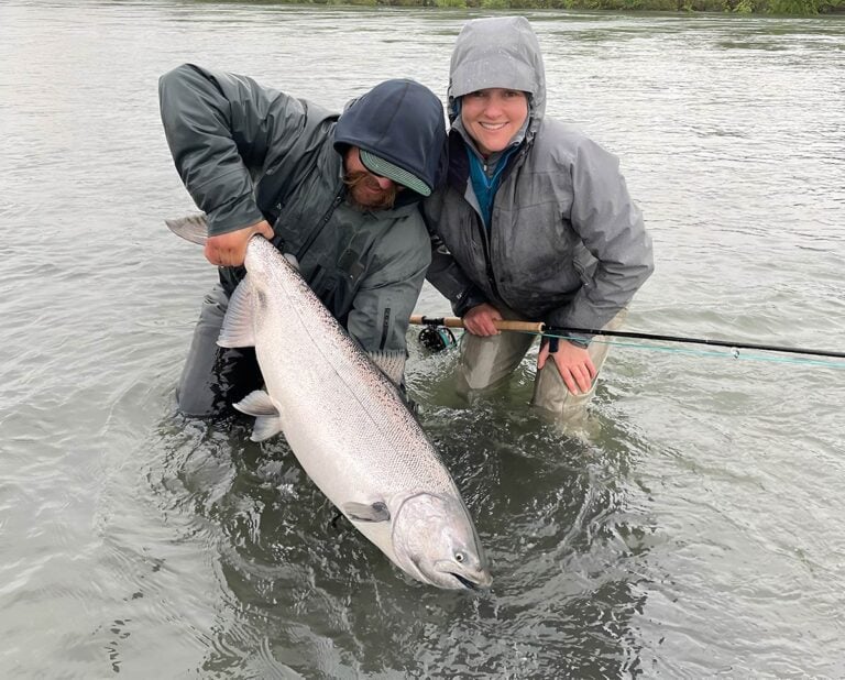 Fishing camp in Alaska, river angler holding king salmon