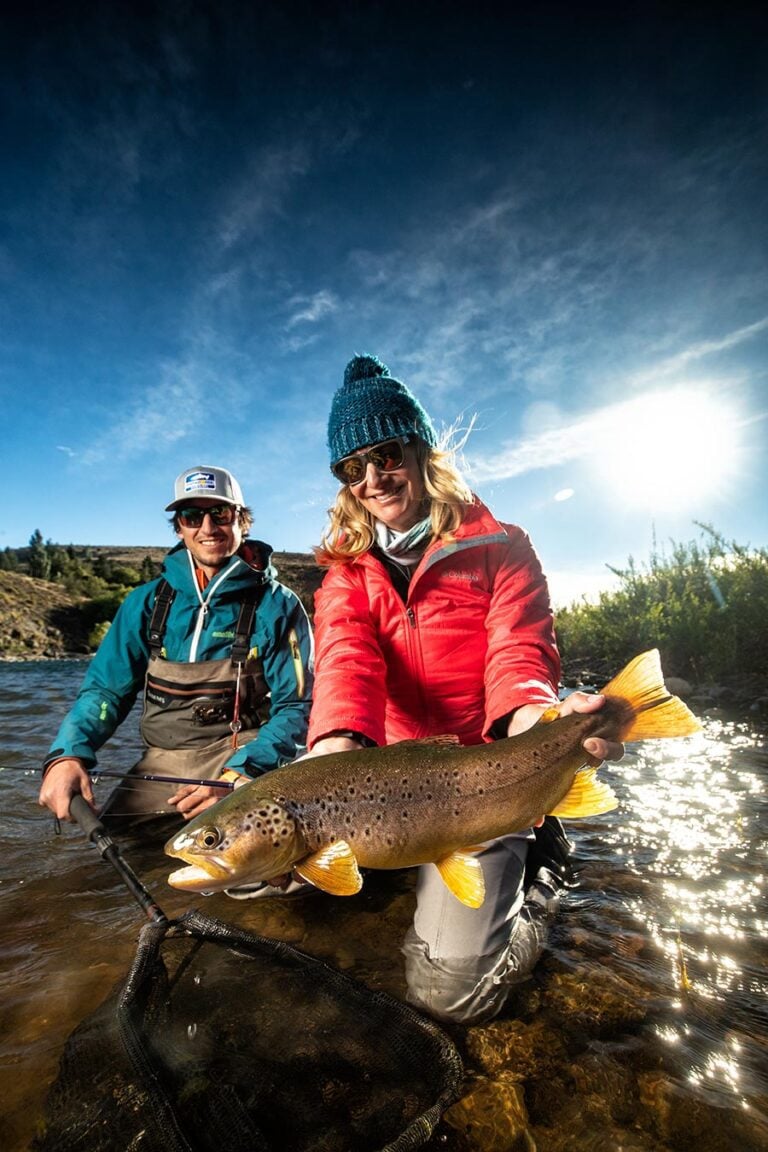 Big trout held by woman angler and guide