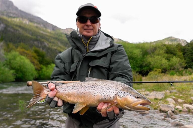 Angler holding brown trout, Chile