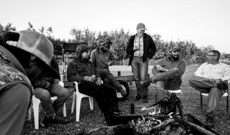 Alaska fisherman sitting around camp fire