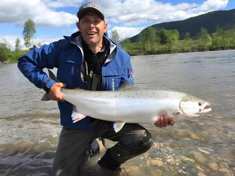 Norwegian fly fishing angler with salmon