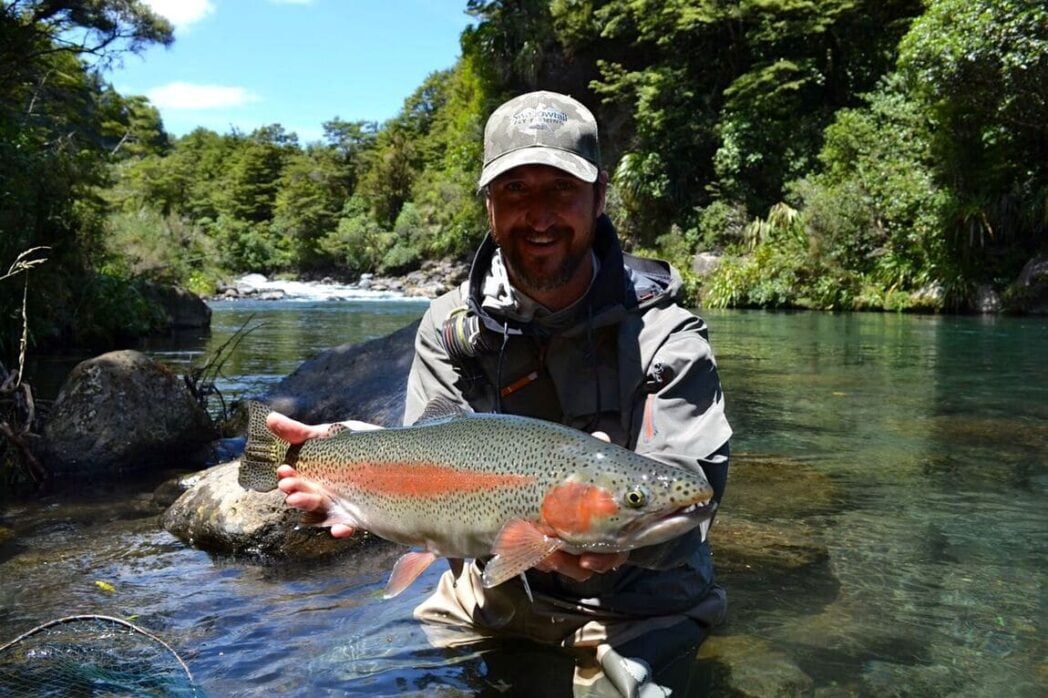 Rainbow trout held by angler in New Zealand river