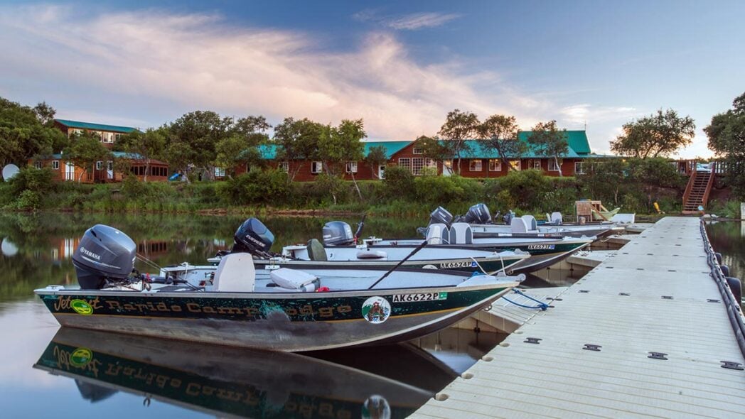 Boats moored to jetty at Rapids Camp Lodge, Alaska