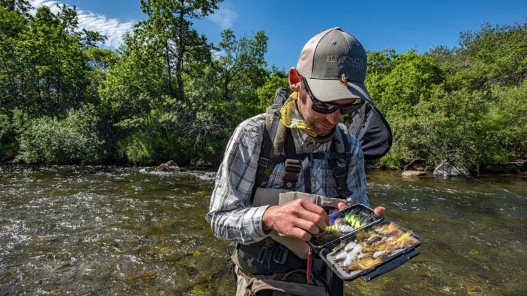 Angler selecting flies standing in river