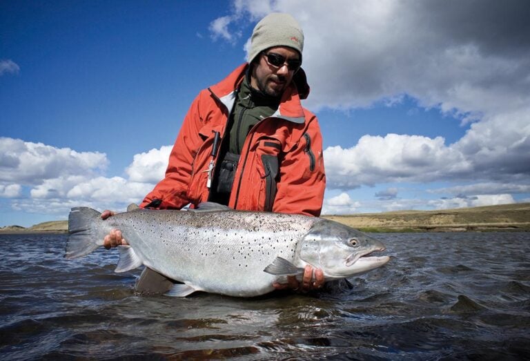 Man holding large sea-run brown trout in Argentina