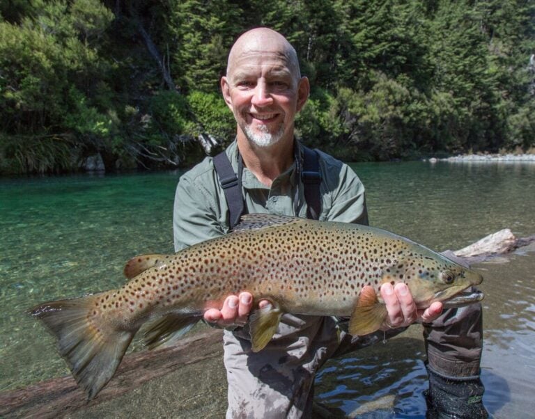 Man holding large brown trout fishing New Zealand, Tongariro Lodge