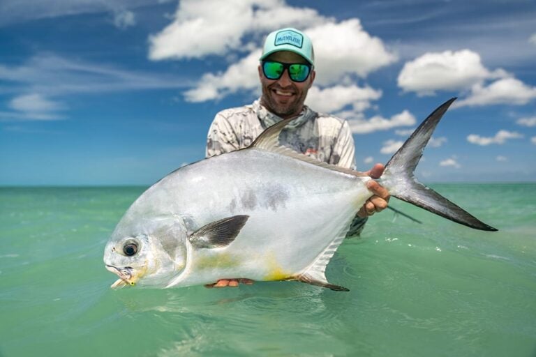 Permit fly fishing, angler holding trophy fish