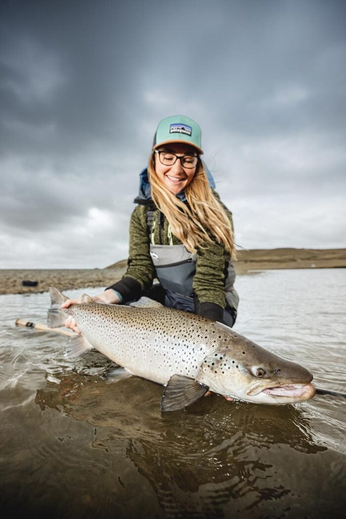 Woman holding trophy sea-run brown trout, Argentina