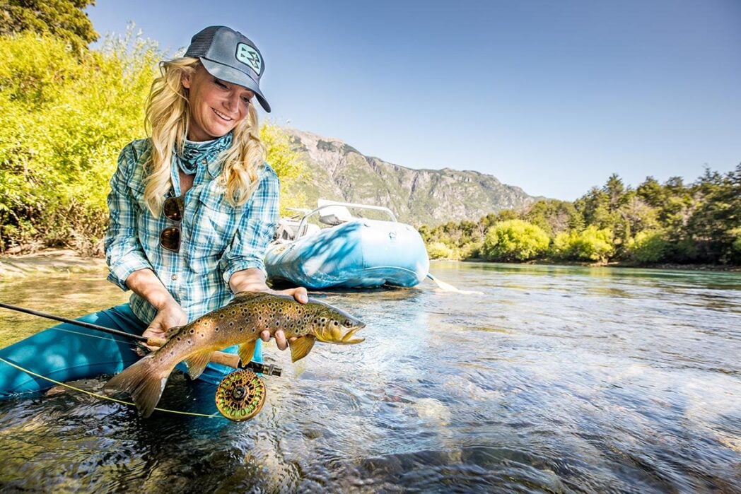 Woman fly fisher returning trout