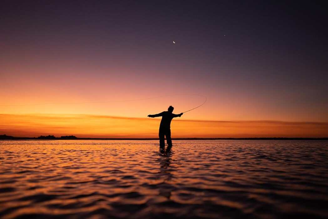 Fly fisherman in sunset