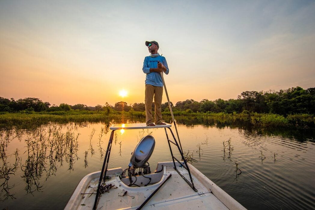 Fishing guide standing on skiff boat