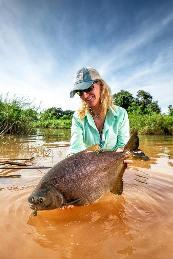 Woman holds up Pacú caught fishing