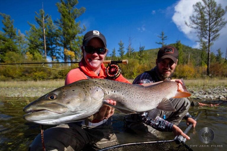 Taimen trout held by female angler