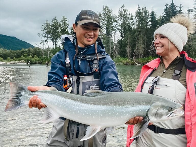 Bristol Bay fishing — guide and angler with large char on the Iliamna River Alaska