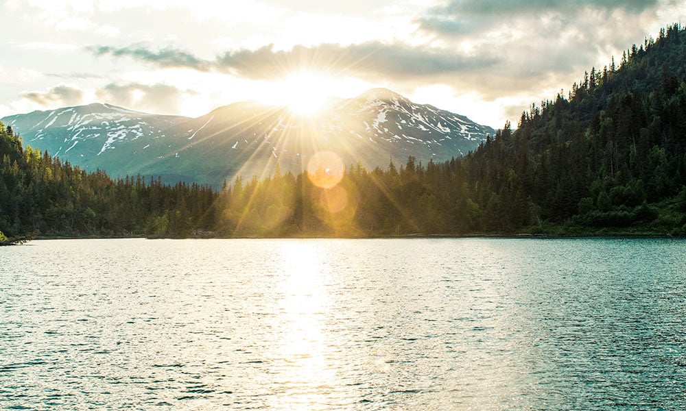 Sunset setting behind mountain and lake landscape in Alaska