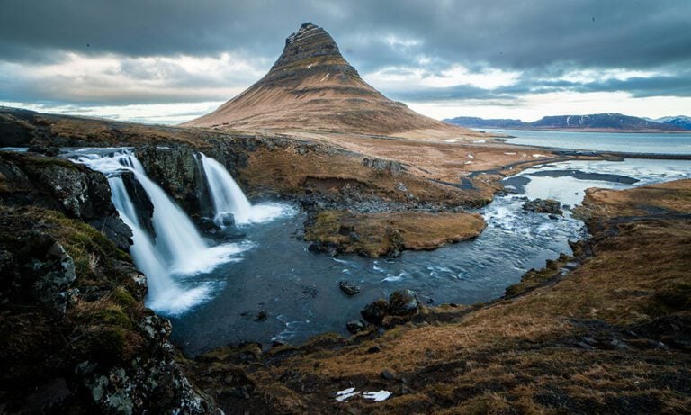 Dramatic waterfall in Iceland with a mountain in background