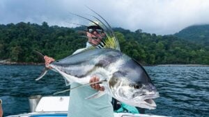 Angler holds massive rooster fish caught popper fishing from boat in Colombia