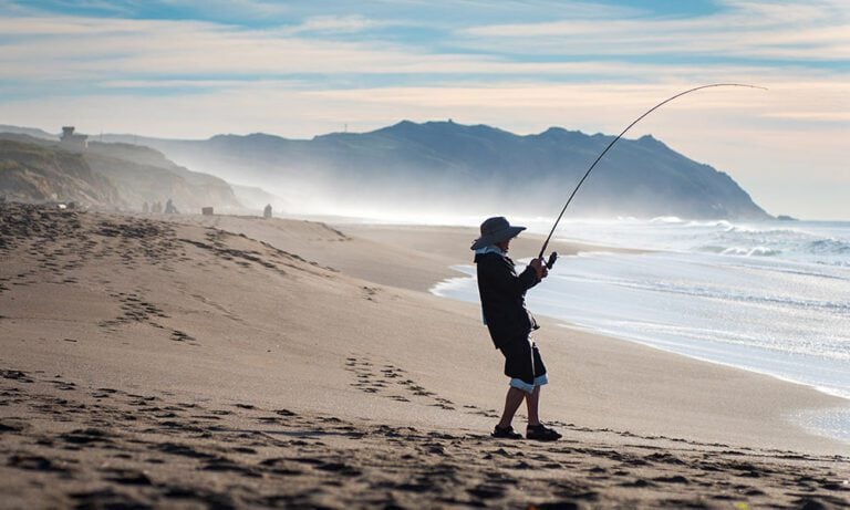 Angler playing a fish which has been caught from the beach