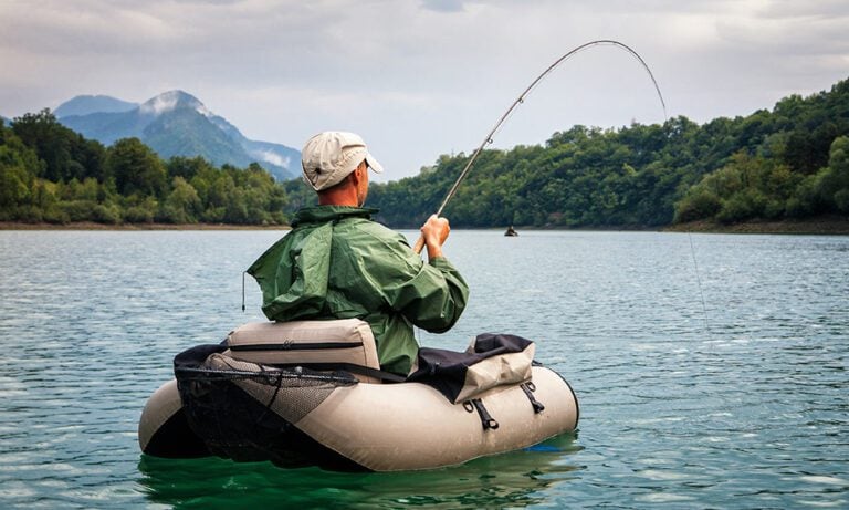 Angler playing fish while float tube fishing on a lake