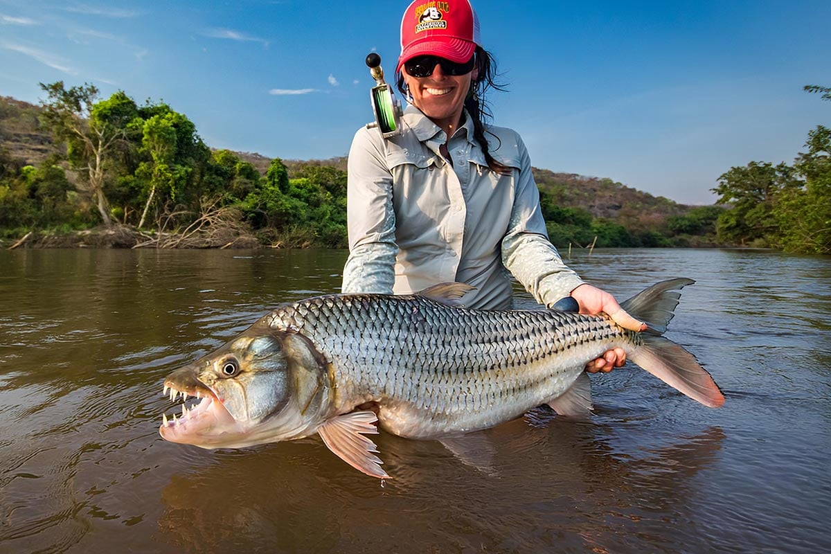 Female angler holding a tigerfish caught on the fly in Africa