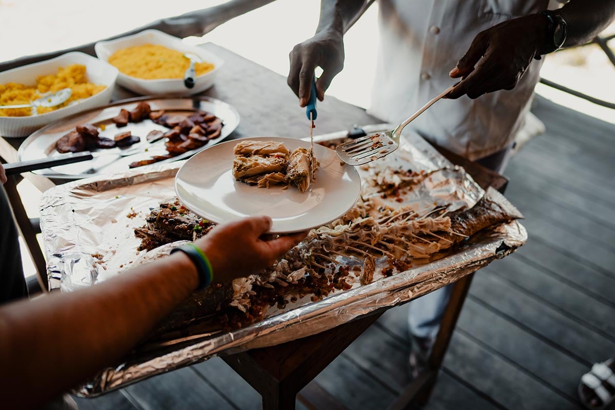 Grilled fish being served to guests at fishing camp in West Africa