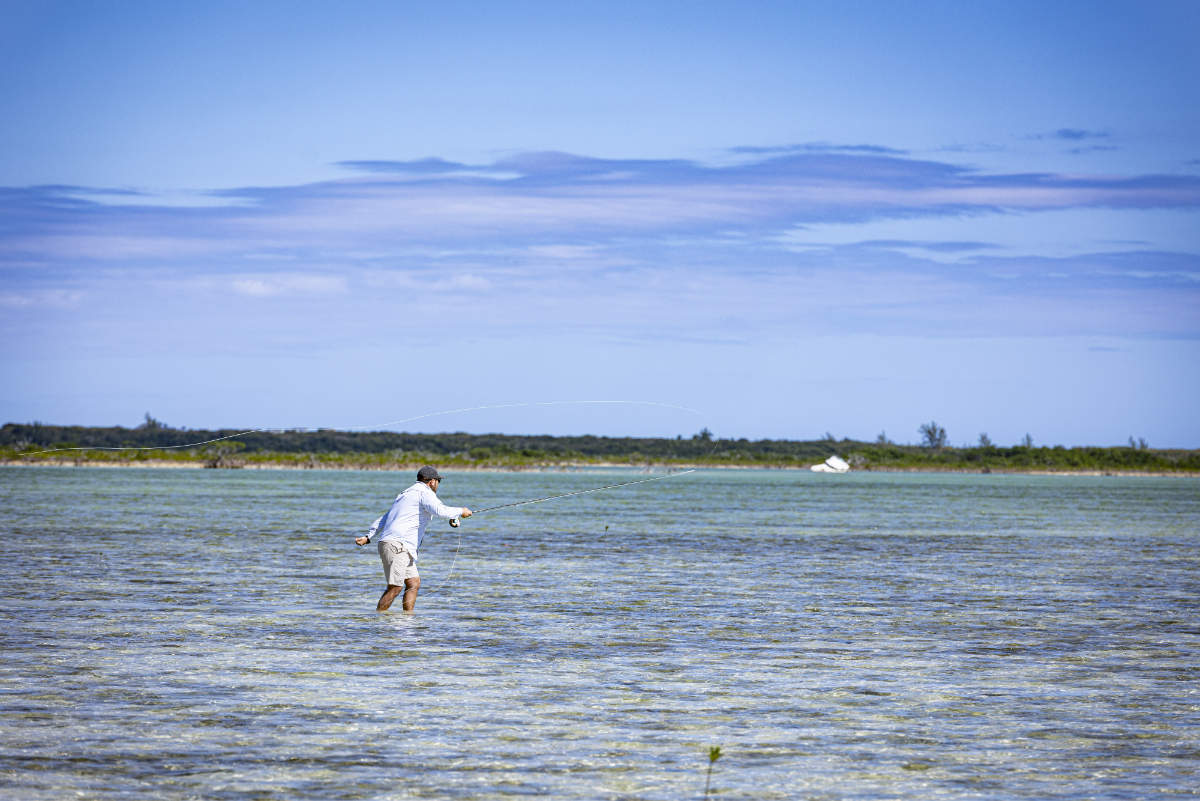 Angler casting fly to bonefish on the flats of Cherokee Bay, Bahamas