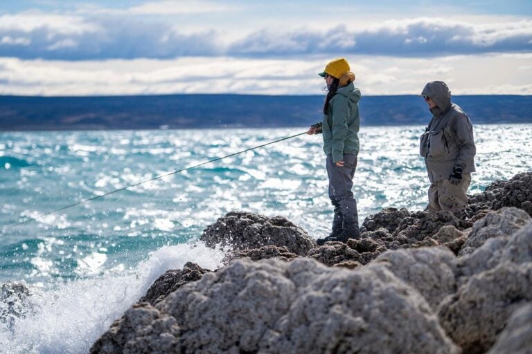 Fly anglers casting from rocky shoreline on Jurassic Lake near Estancia Laguna Verde, southern Patagonia trout fishing